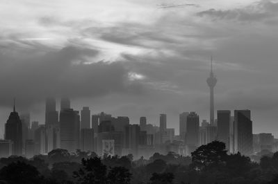 Buildings in city against cloudy sky