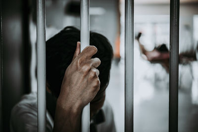 Man standing behind security bar