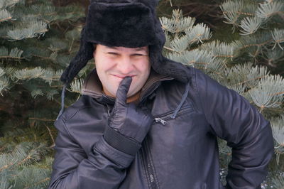 Smiling man standing against tree