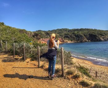 Rear view of woman standing on shore