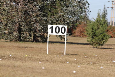 Information sign on road amidst trees