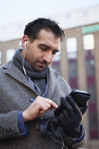 Businessman using phone outdoors in city