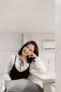 Young woman using mobile phone while sitting at home