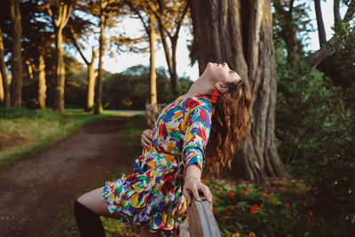 Side view of woman wearing hat on tree