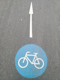 High angle view of arrow and bicycle signs on road