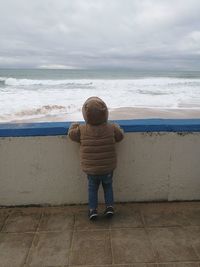 Rear view of boy standing on beach