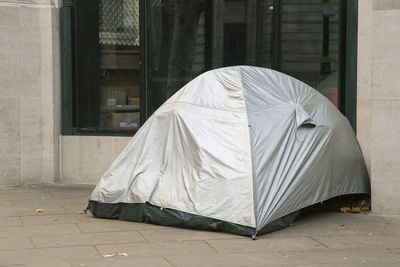 White umbrella on street by footpath against building