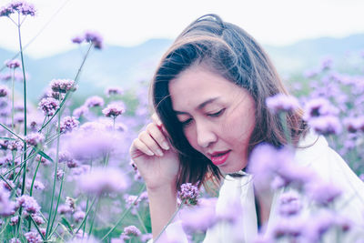 Portrait of woman against purple flowering plants