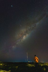 Rear view of woman standing against star field at night