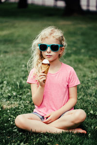 Cute funny adorable girl in sunglasses with dirty nose and moustaches eating ice cream 