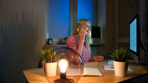 Portrait of woman sitting on bed at home