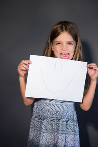 Portrait of a smiling girl holding smart phone