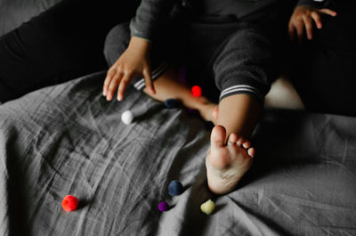 Low section of woman holding hands on bed