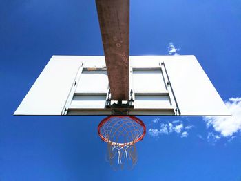 Low angle view of basketball hoop against blue sky