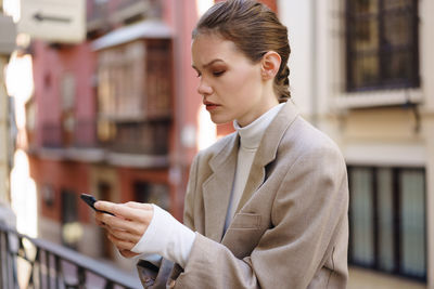 Side view of young man using mobile phone