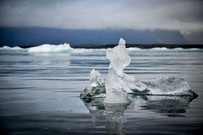 Frozen sea against sky during winter