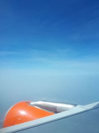 Airplane flying over sea against blue sky