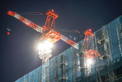 Low angle view of crane against sky at night