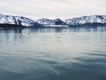 Scenic view of lake and snowcapped mountains against sky