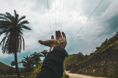 Low angle view of woman with arms raised against sky
