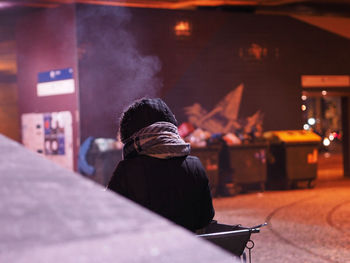 Rear view of woman in illuminated city at night