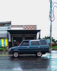 Vintage car on street against buildings in city