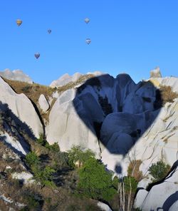 Low angle view of rocks against clear blue sky