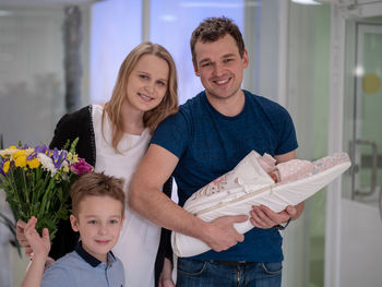 Portrait of smiling family with newborn baby