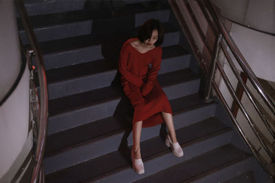 High angle view of young woman sitting on steps