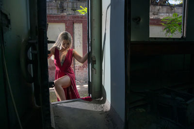 Side view of girl standing by window