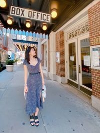 Full length of woman standing against illuminated building