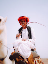 Portrait of bedouin young man on his camel in the desert 