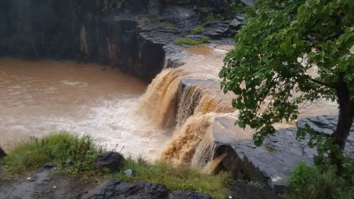 High angle view of stream flowing through rocks