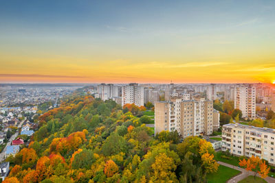 High angle view of trees and buildings against sky during sunset