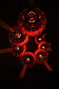 Low angle view of illuminated lanterns hanging against black background