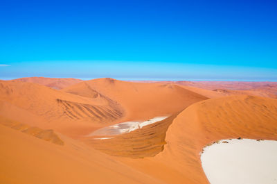 Scenic view of desert against clear blue sky