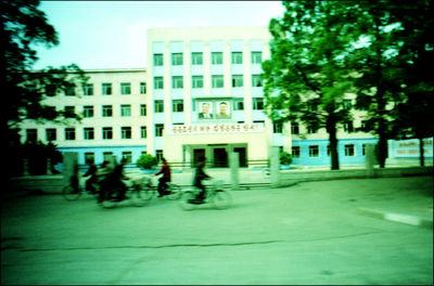 People walking on street against buildings in city