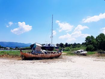 Boats moored on beach against sky