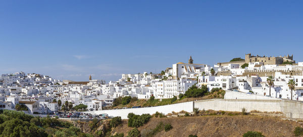 Buildings in city against clear blue sky