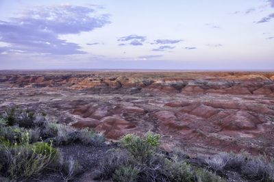 Rock formations on landscape against cloudy sky