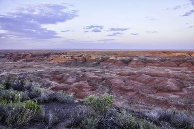 Rock formations on landscape against cloudy sky