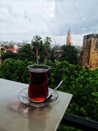 Wet glass on table against window during rainy season