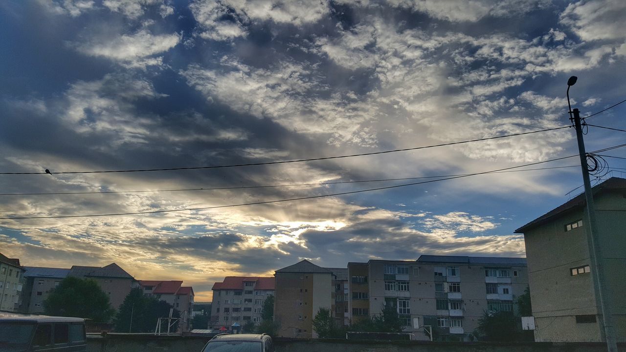 LOW ANGLE VIEW OF HOUSES AGAINST CLOUDY SKY