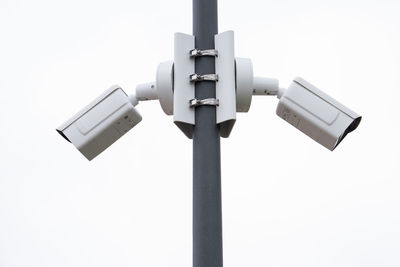 Low angle view of security camera against clear sky
