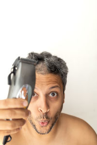 Portrait of young woman using mobile phone against white background