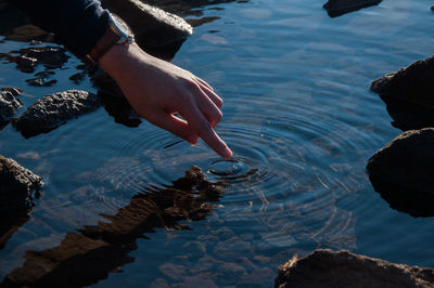 High angle view of person hand on rock