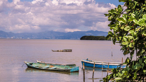 Boats moored on sea against sky