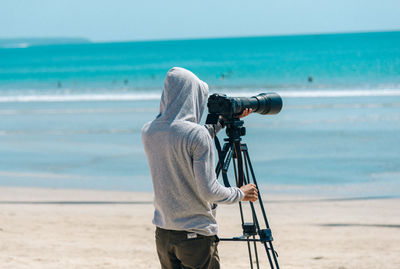 Rear view of person photographing sea