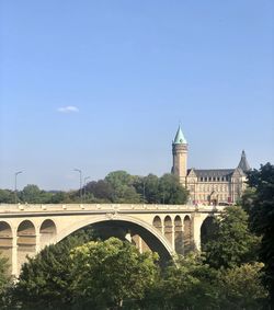 Arch bridge in city against sky