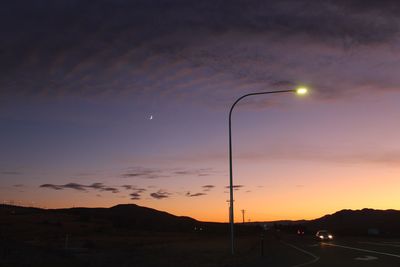 Silhouette road against sky at dusk